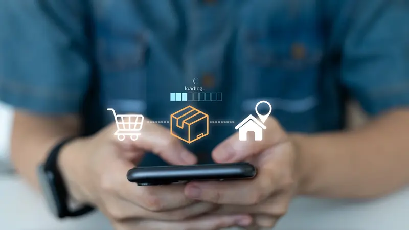Hände halten ein Smartphone, darüber Symbole für Warenkorb, Paket und Zuhause